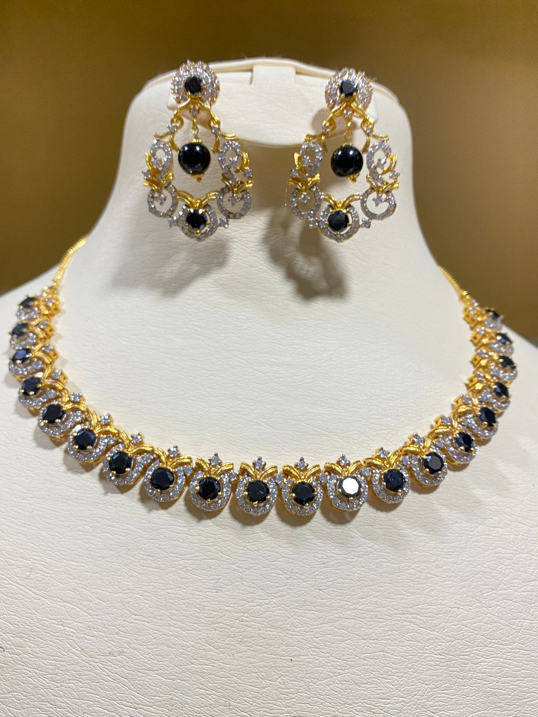 Black stones and zircon. Gold plated.