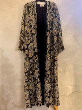 Load image into Gallery viewer, RetrolaneTreasures black long kimono cardigan with gold paisley print and shimmering threads. Flowing fabric with wide sleeves.
